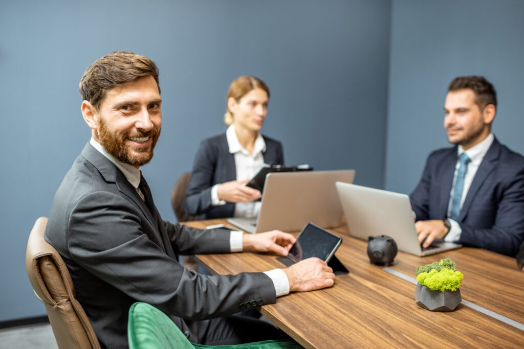 Portrait of a handsome smiling business man sitting during a conference with business partners in the meeting room
